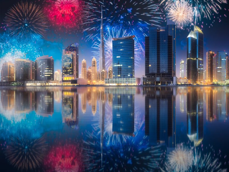 Beautiful fireworks above Dubai Business bay at evening light with reflection on water, UAE