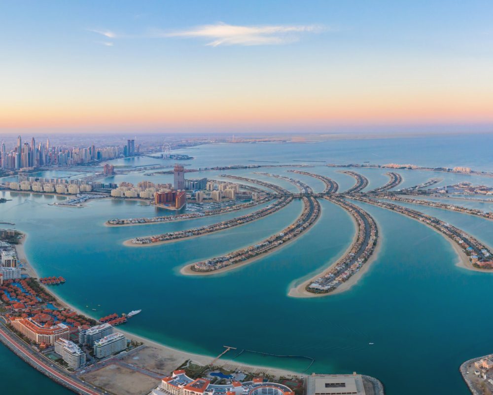 Aerial view of The Palm Jumeirah Island, Dubai Downtown skyline, United Arab Emirates or UAE. Financial district and business area in smart urban city. Skyscraper and high-rise buildings at sunset.